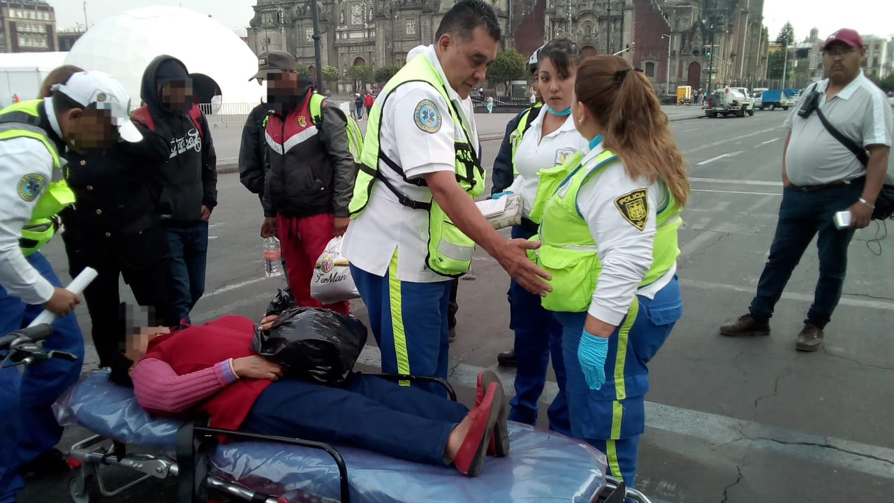 Paramédicos del ERUM de la SSC brindan apoyo médico a dos mujeres que se manifestaban en la plancha del Zócalo